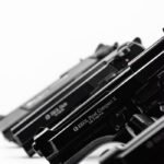 Monochrome image showcasing a lineup of handguns in a diagonal arrangement.